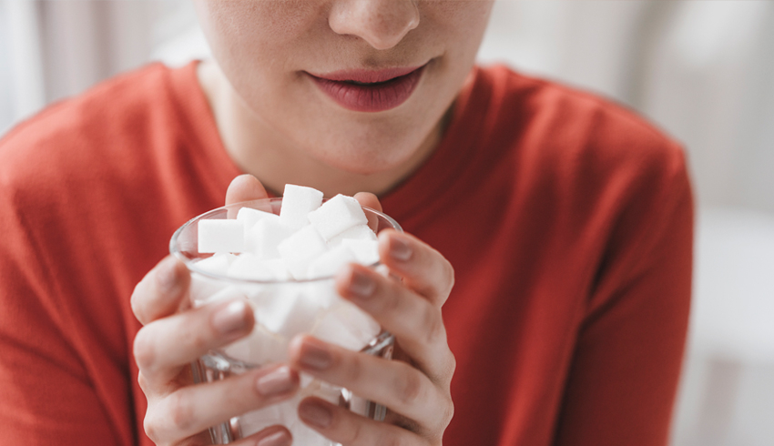 Woman holding a cup of sugar cubes